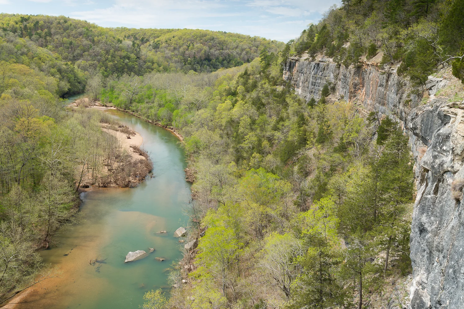 The Current River bending beneath a limestone bluff